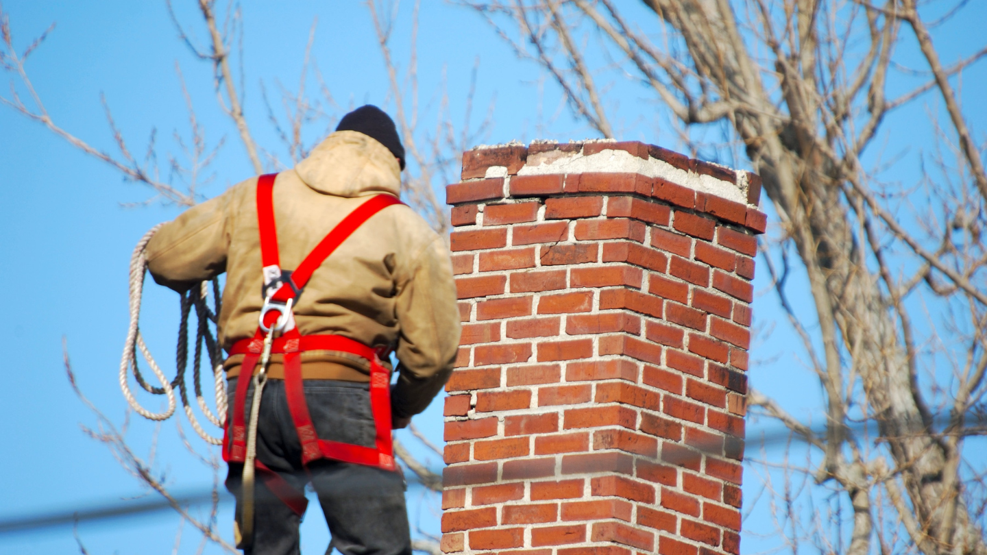 Roofer repointing a chimney in Bristol