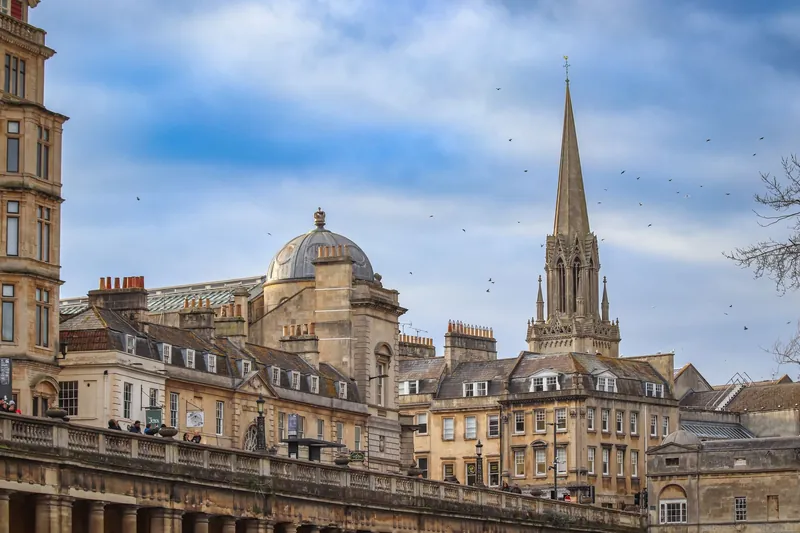 Honey-coloured Georgian buildings, a dome and a church spire on the Bath skyline