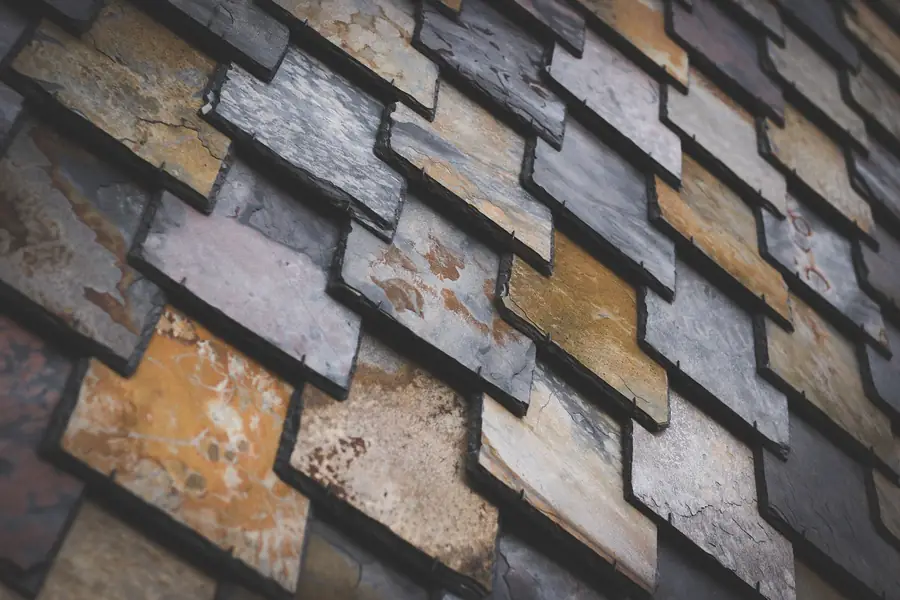 Close-up of weathered natural slates in mixed grey, rust and ochre tones